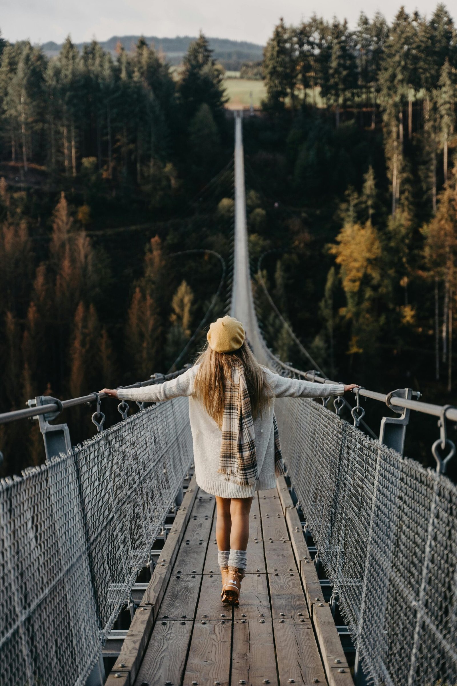 young girl crossing a bridge